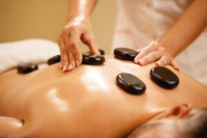 Man having hot stone massage vs. swedish massage