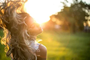 Woman enjoying morning sunlight as part of a wellness routine for busy people focused on energy and healthy daily habits.